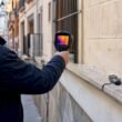 Especialista revisando un edificio con una cámara térmica para detectar posibles problemas.