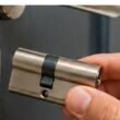 Mano sustituyendo el bombín de una cerradura de puerta