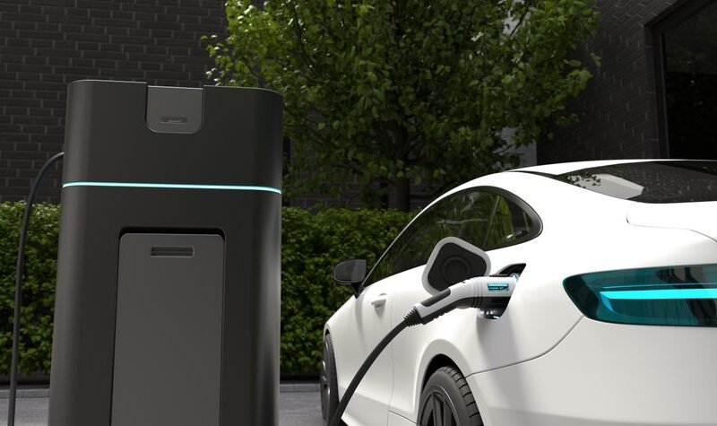 Cargador coche eléctrico casa instalado junto a un vehículo