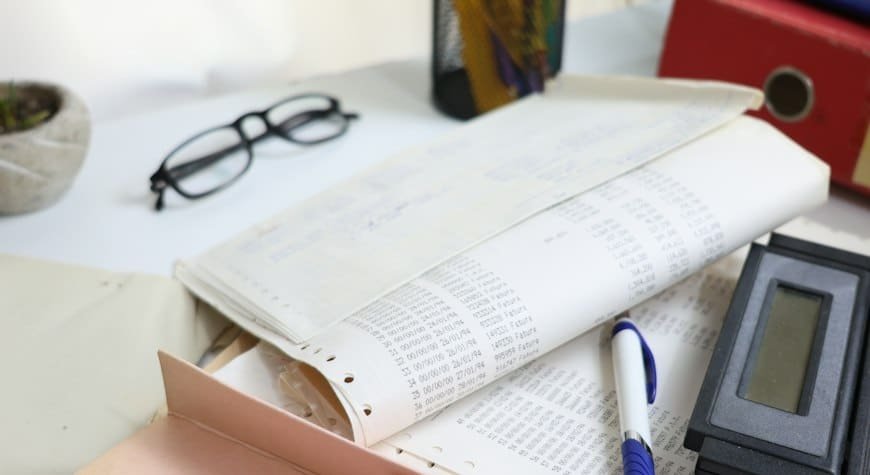 Documentos y calculadora sobre una mesa para ilustrar la gestión fiscal de una comunidad de propietarios