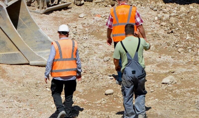 Cimentación de una casa con trabajadores vertiendo hormigón