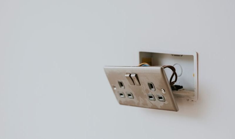 Enchufe quemado y dañado en una pared