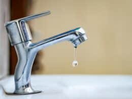 Grifo gotea con una fuga de agua en una instalación doméstica