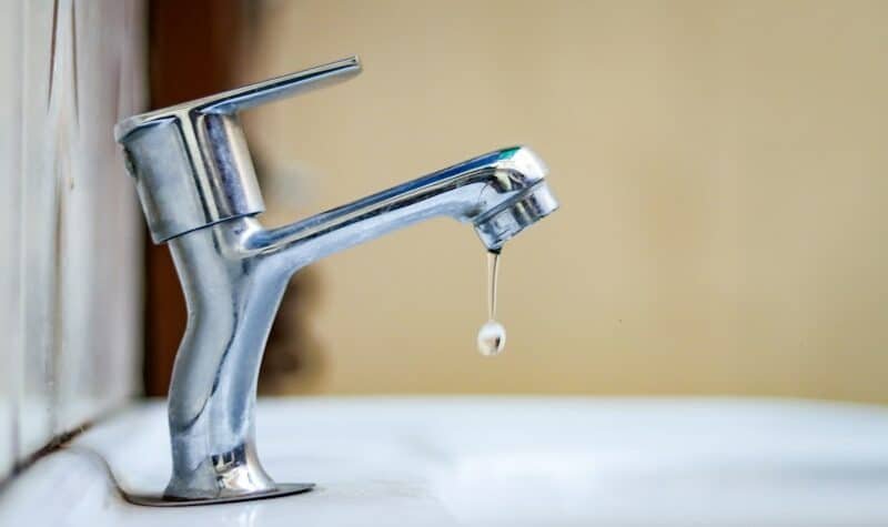 Grifo gotea con una fuga de agua en una instalación doméstica