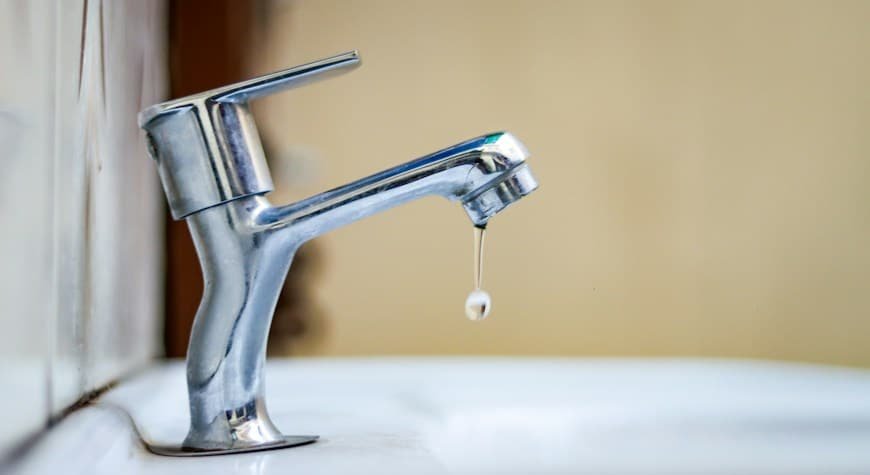 Grifo gotea con una fuga de agua en una instalación doméstica