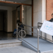 Acceso accesible a una comunidad de propietarios con rampa y persona en silla de ruedas