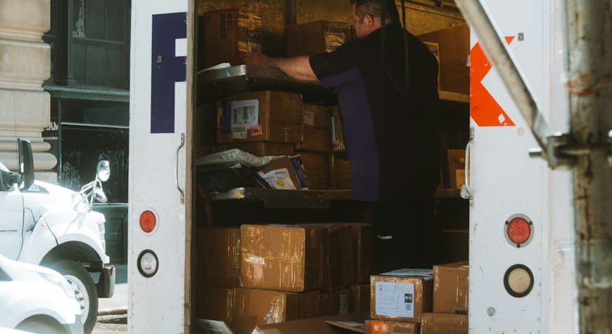 Persona cargando cajas de cartón en un camión de mudanzas