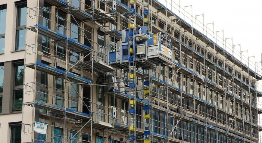 Rehabilitación de fachadas de edificio con andamios y trabajos de renovación